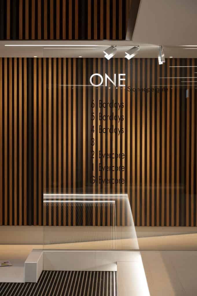 DSC_3271 Wall with vertical wooden slats displaying floor directory signage, listing Barclays on floors 4 to 6 and Evercore on floors G to 2.