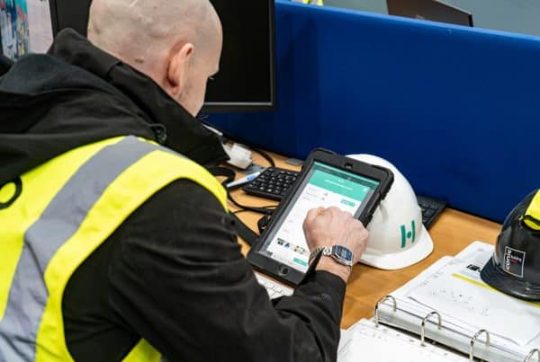 construction worker sitting at desk working on a tablet