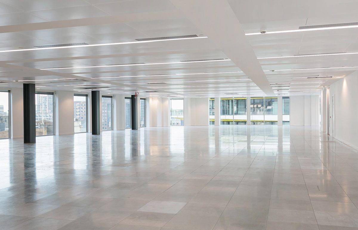 Refurbished open-plan office space featuring polished flooring, upgraded lighting and ventilation, and structural black columns, offering a bright, modern canvas ready for flexible workspace configuration.