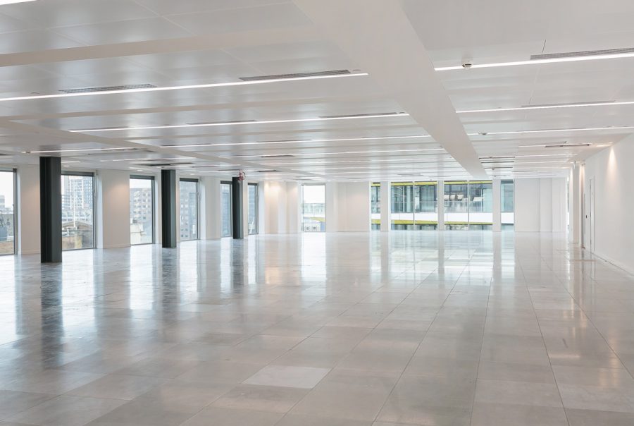 Refurbished open-plan office space featuring polished flooring, upgraded lighting and ventilation, and structural black columns, offering a bright, modern canvas ready for flexible workspace configuration.