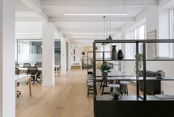 Refurbished open-plan office featuring sleek desks, modern seating, and decorative shelving—enhanced by natural light and minimalist finishes for a refreshed, collaborative workspace.