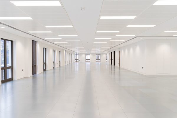 Fully refurbished open-plan office floor with new LED ceiling panels, freshly painted white walls, upgraded grey flooring, and newly fitted full-height windows.