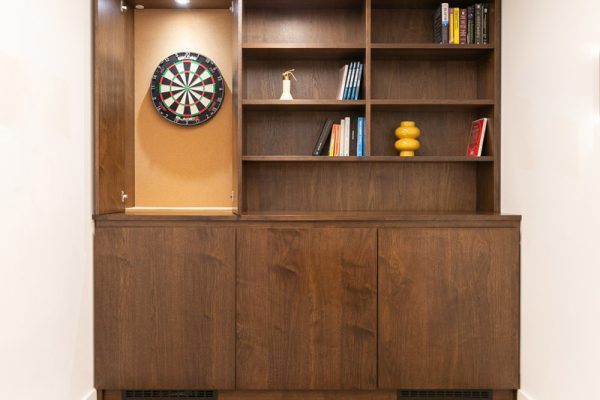 Bespoke joinery installation with concealed dartboard cabinet, combining recreation and storage elements within a refreshed office space.