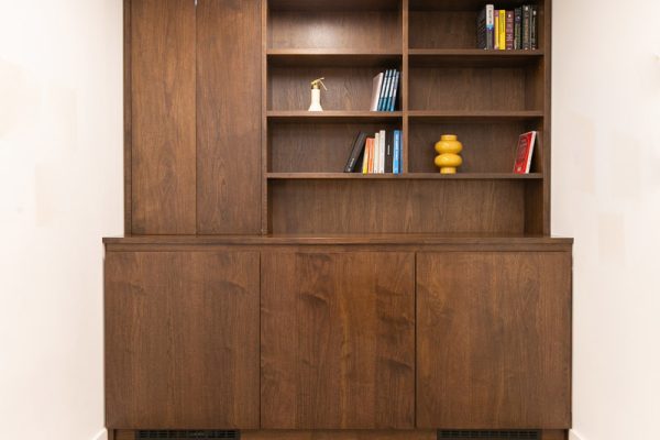 Bespoke timber joinery installed as part of the fit‑out, providing built‑in storage and open shelving within a freshly refurbished office corridor.