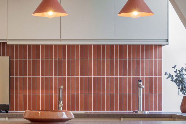 Detail of CAT B kitchen fit out with feature pendant lighting, tiled splashback and integrated appliances.