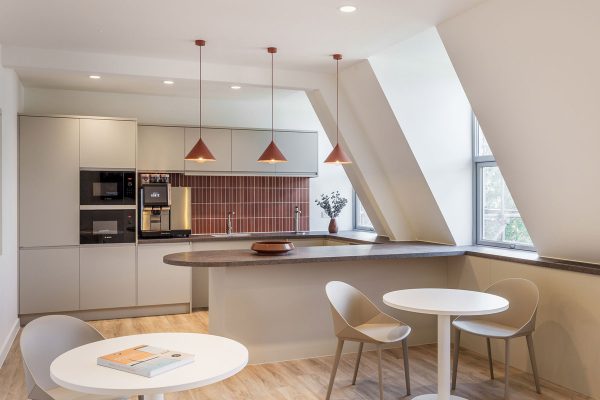 CAT B breakout kitchen and seating area with custom joinery, high-level storage and soft workplace finishes.